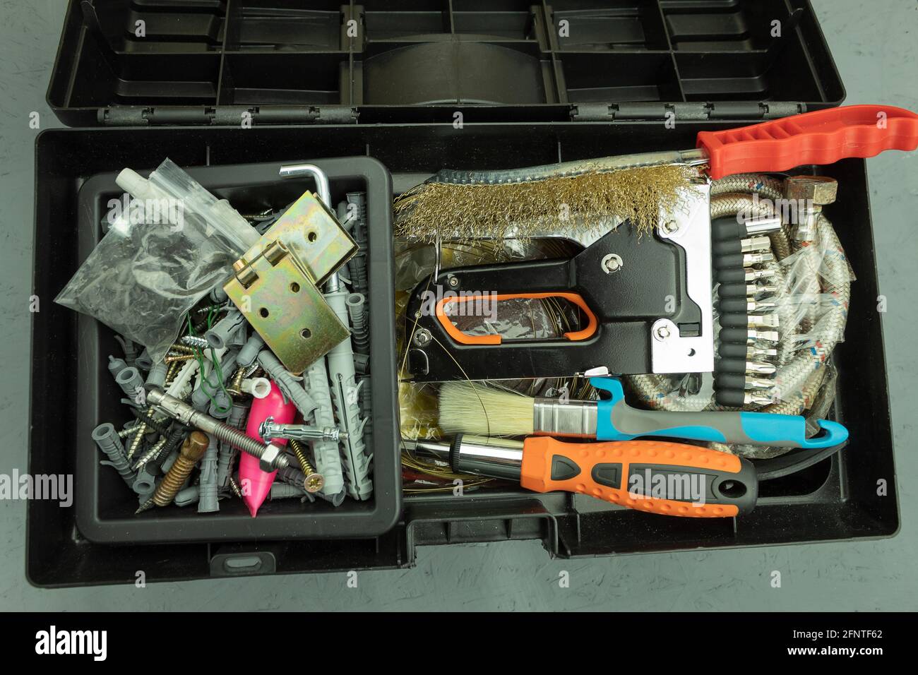Open large black box for construction tools. Carrying case with many tools on gray background Stock Photo