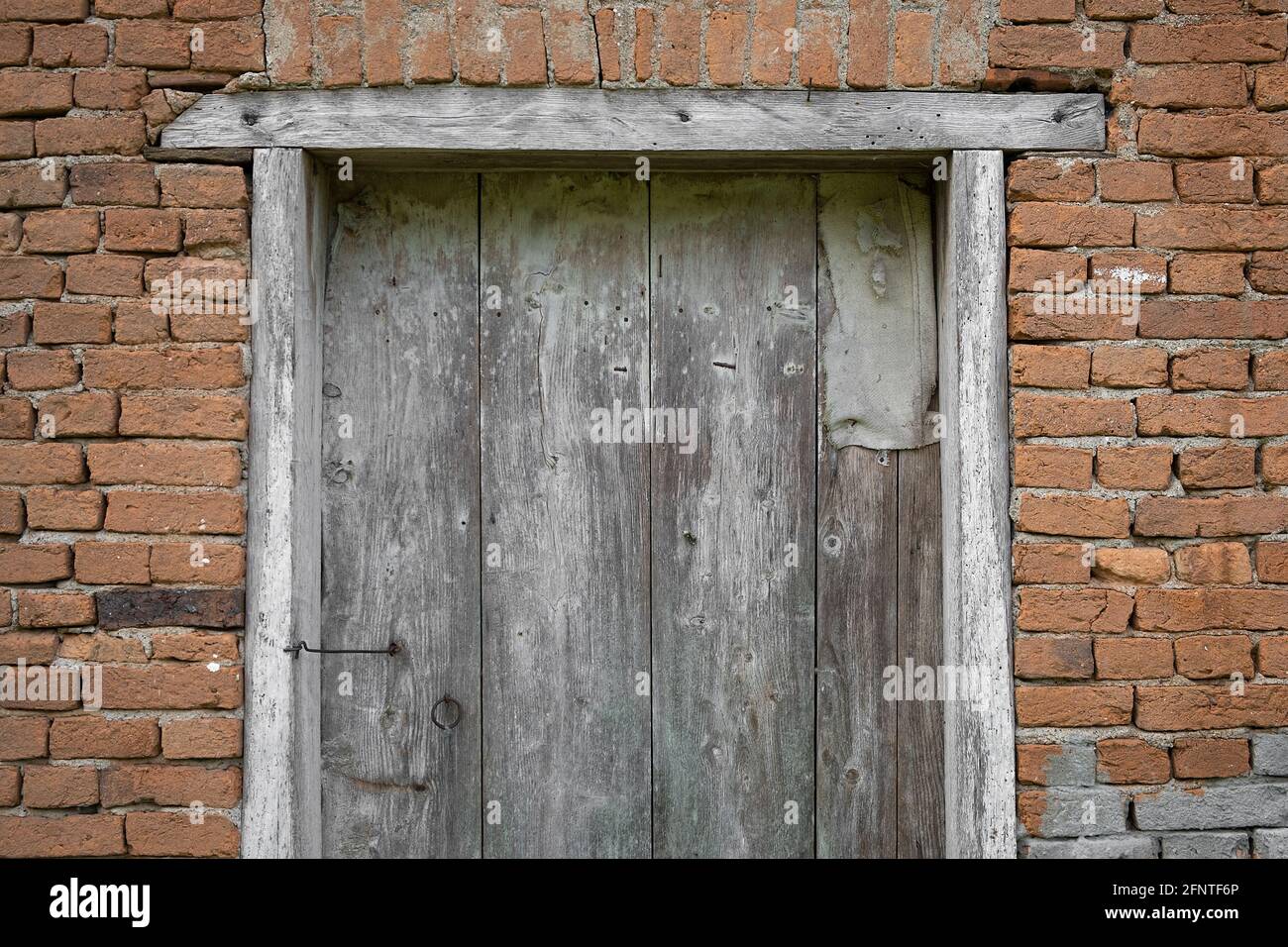 Closed old, rustic, wooden barn door and red brick wall Stock Photo - Alamy