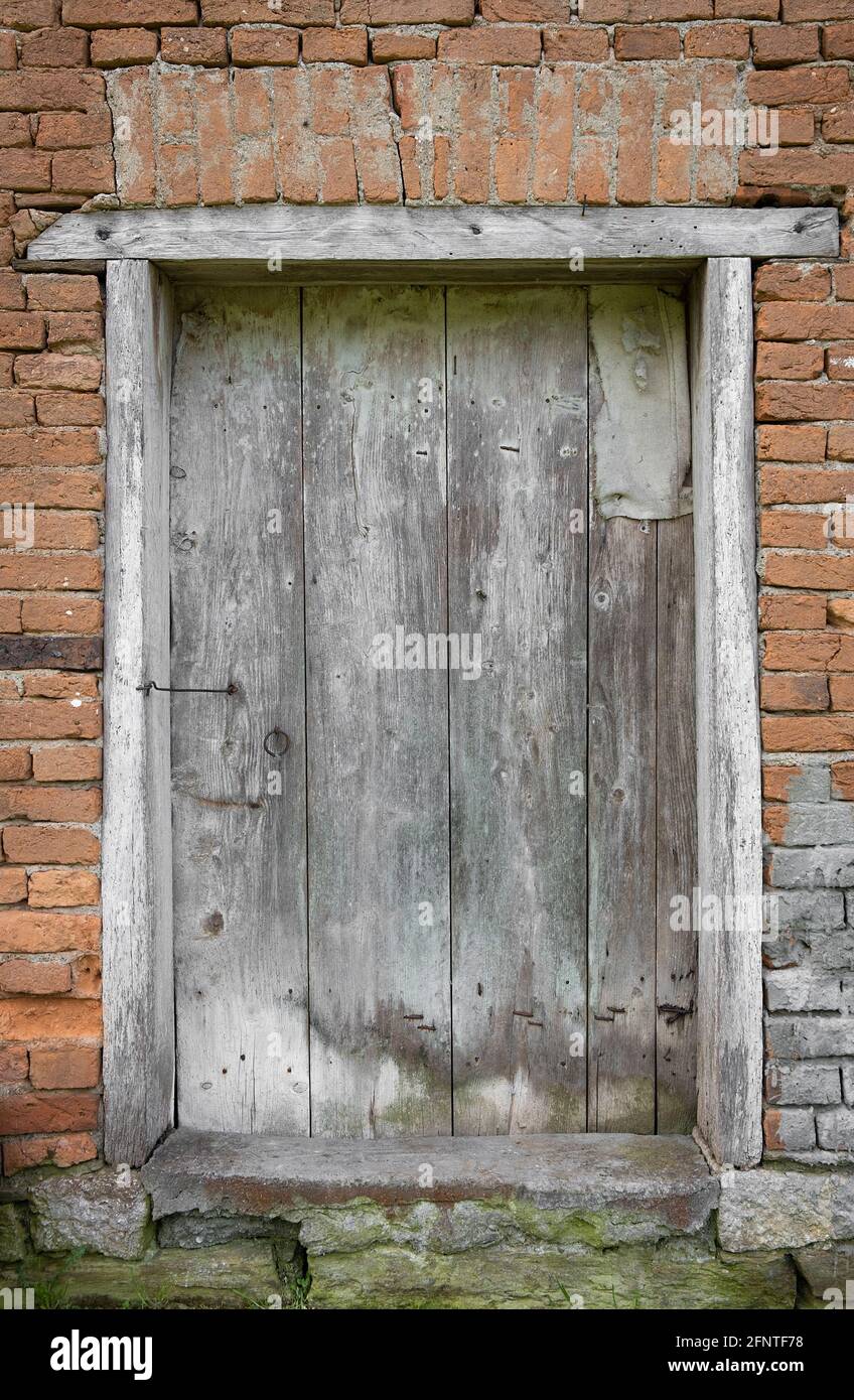 Closed old, rustic, wooden barn door and red brick wall Stock Photo - Alamy
