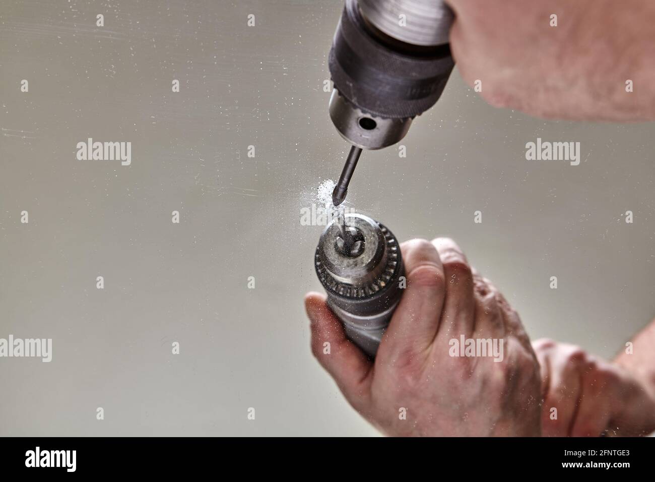 Bit for glass is clamped in drill chuck while drilling mirror Stock