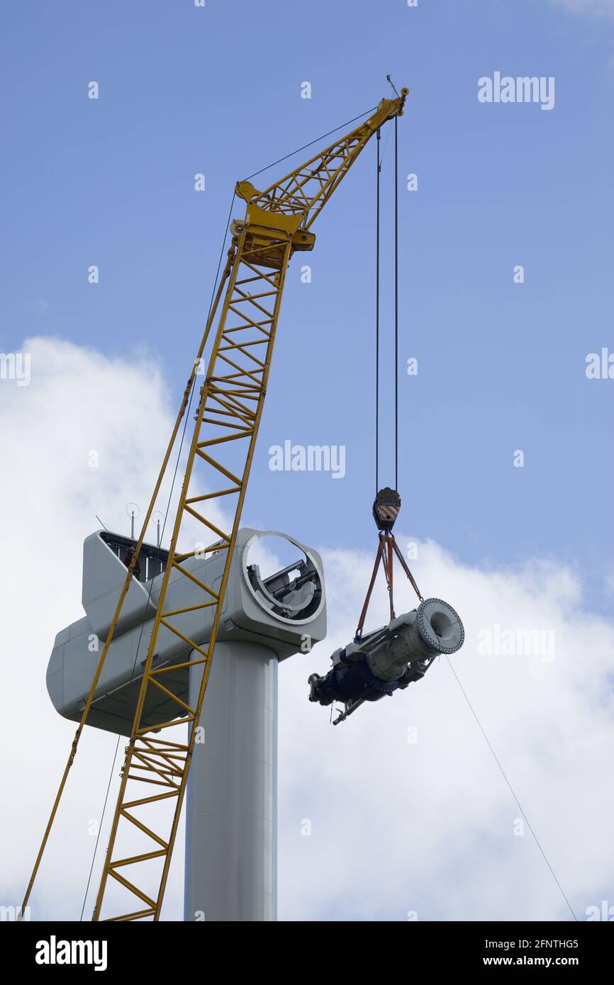 A crawler crane is hoisting the gearbox of a new wind turbine Stock Photo
