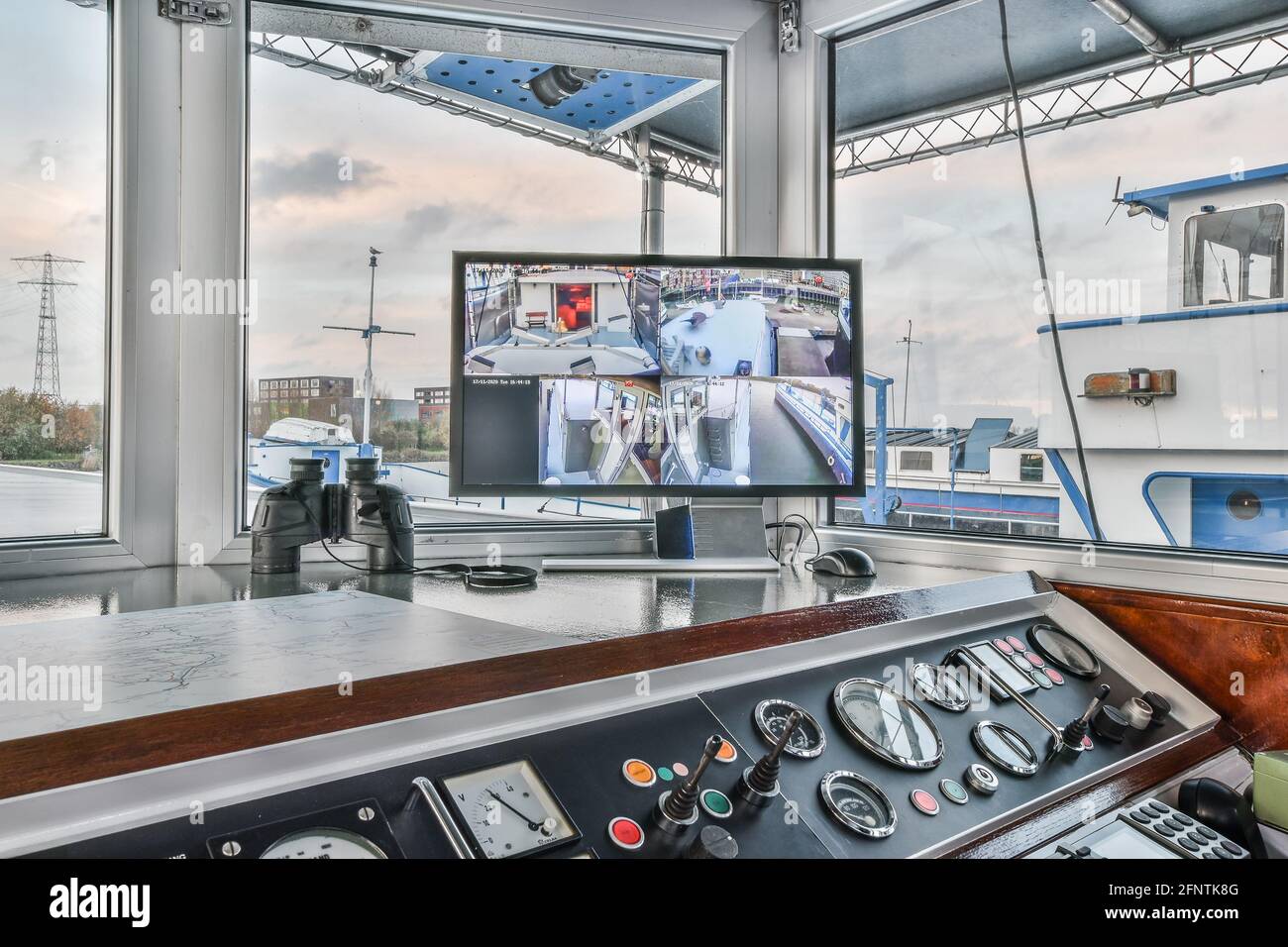 Computer monitor with video from surveillance cameras placed on dashboard near binoculars in cockpit of modern vehicle Stock Photo