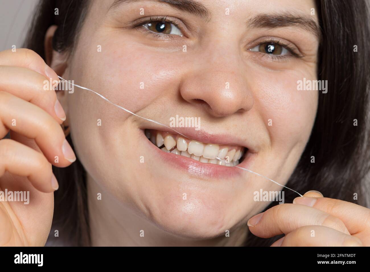 A woman brushes her teeth with flossing. Oral hygiene, plaque