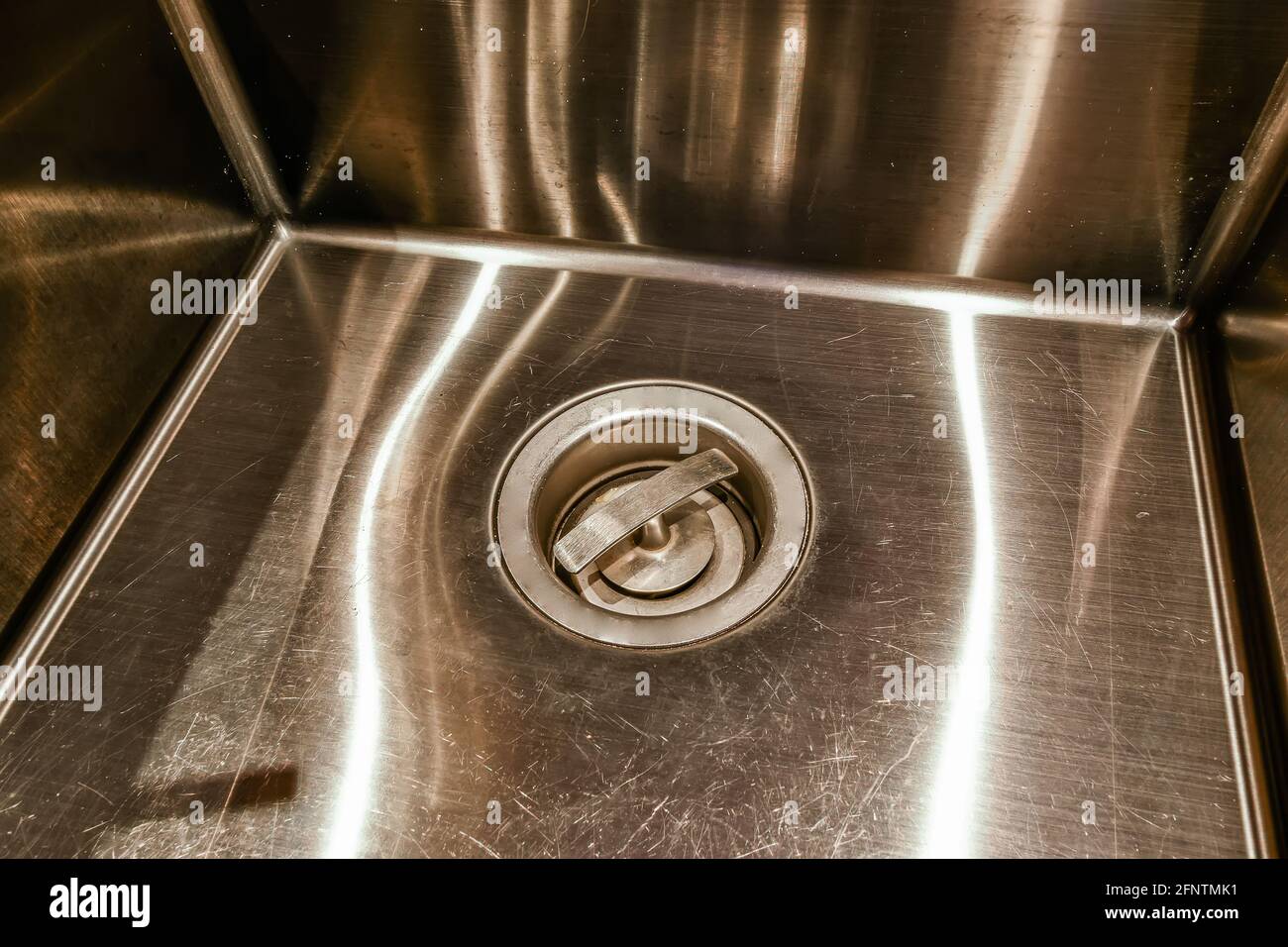 From above plug installed into clean stainless metal sink in kitchen at home Stock Photo
