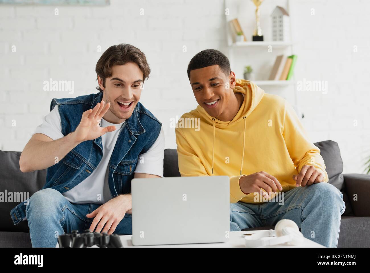 Friends Using Laptop On Sofa Mixed Race Typing Having Photo