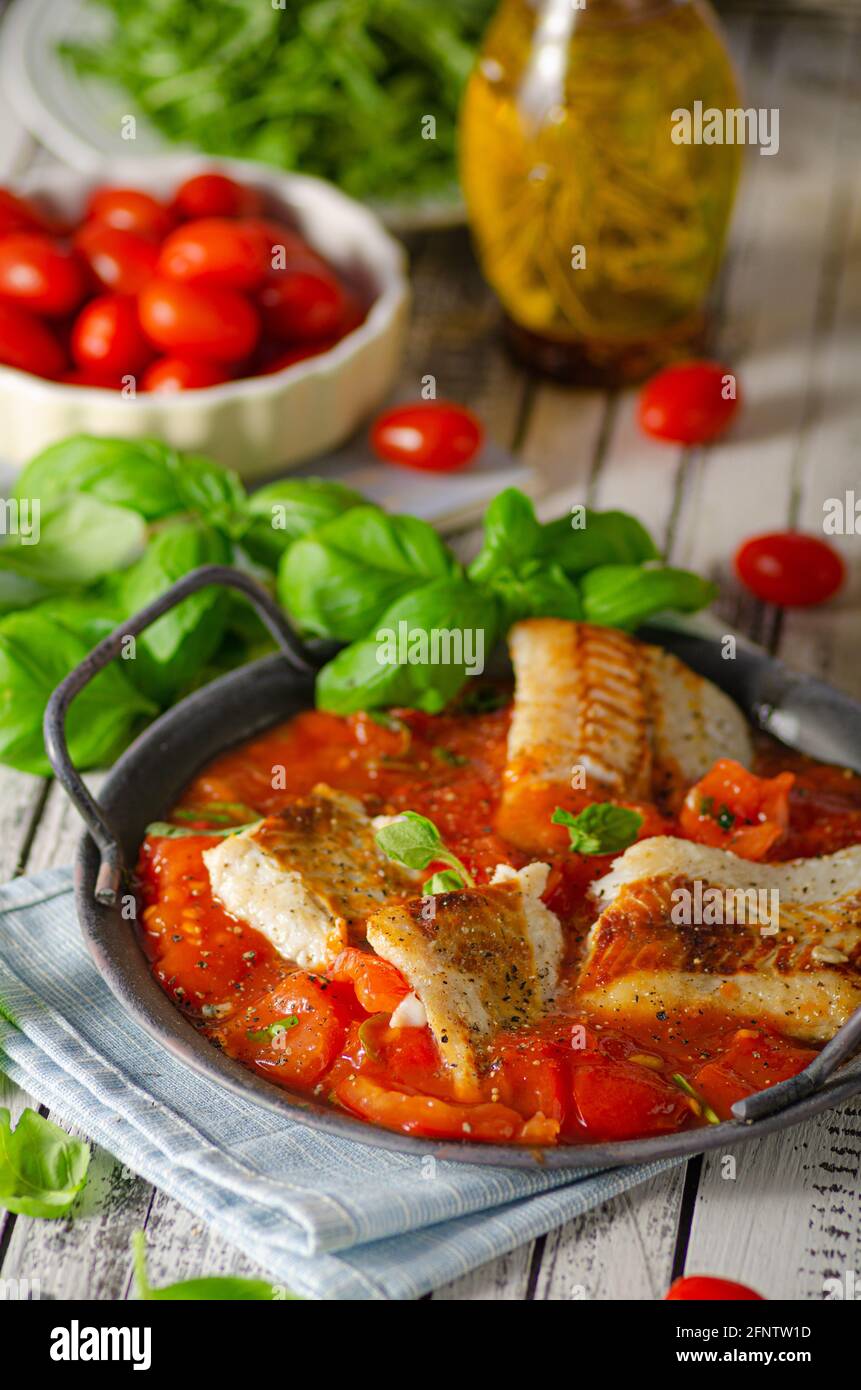 Grilled fish in tomato sauce with basil and herbs Stock Photo Alamy