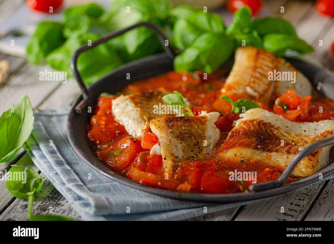 Grilled fish in tomato sauce with basil and herbs Stock Photo Alamy