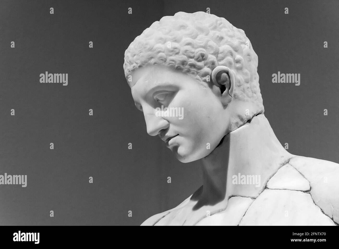 Black and white photo in close-up on face of reconstructed ancient roman sculpture of young man Stock Photo