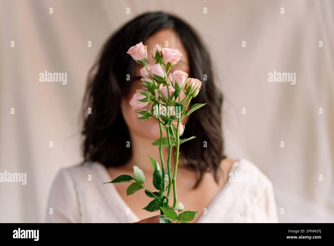 simple portrait of beautiful young woman holding bouquet of blooming ...