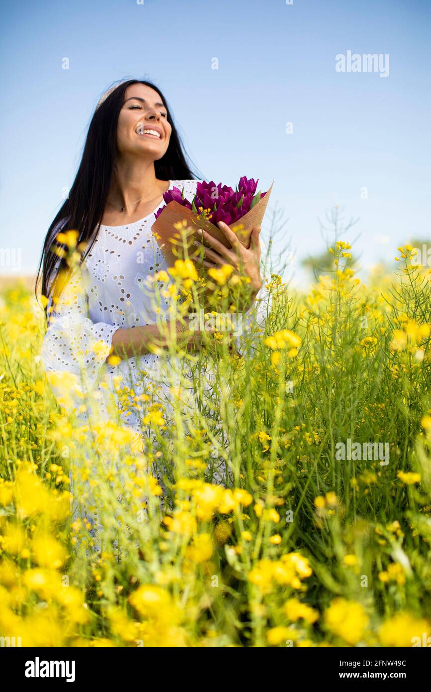 Pretty young woman in the rapeseed field Stock Photo - Alamy