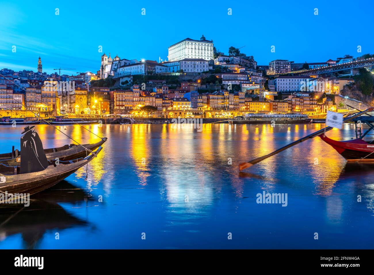 Blick über die traditionellen Rabelo Boote am Douro Ufer in Vila Nova de Gaia auf die Altstadt von Porto in der Abenddämmerung,  Vila Nova de Gaia, Po Stock Photo
