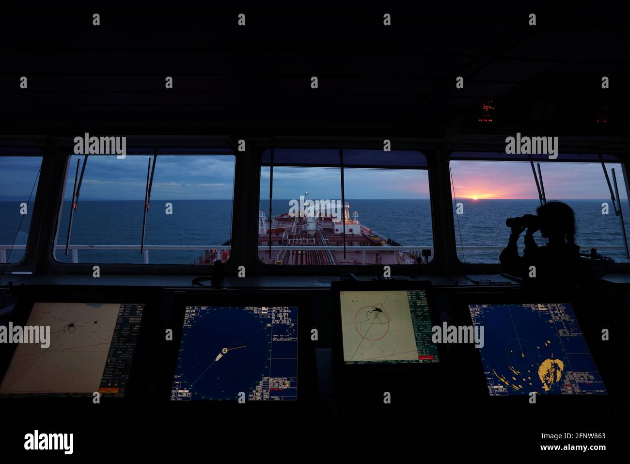 woman deck officer on watch at Tanker ship brige, with arpa radars and ecdis dispalys Stock Photo