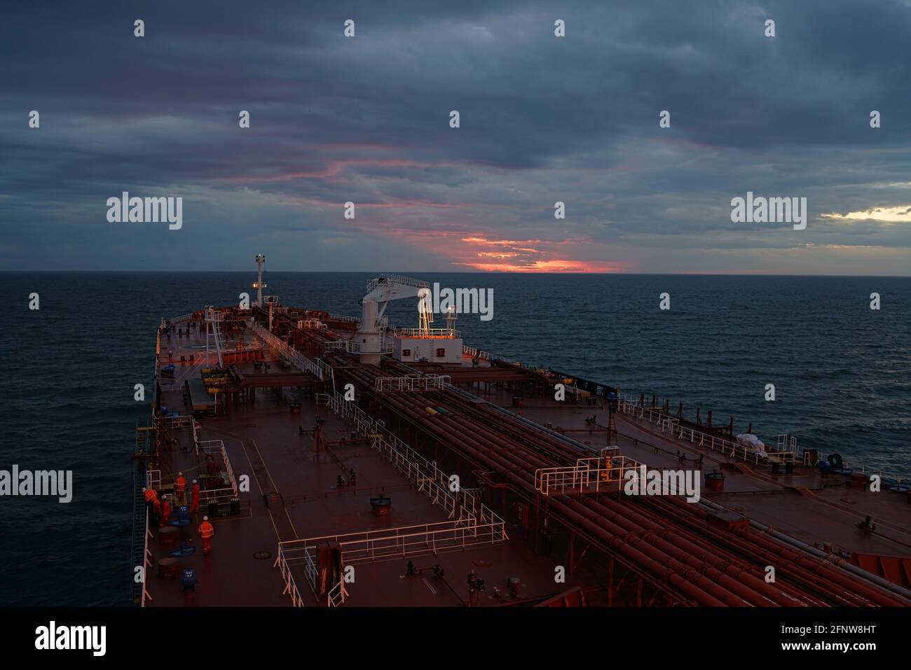 tanker vessel and supply boat at anchorage under sunset lights Stock