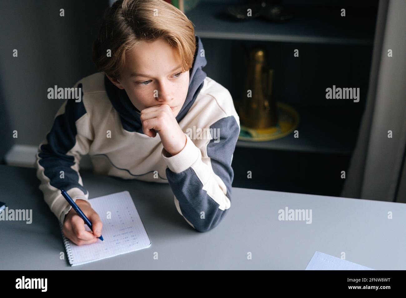 Close-up hands of pupil boy writing in paper notebook solving math ...