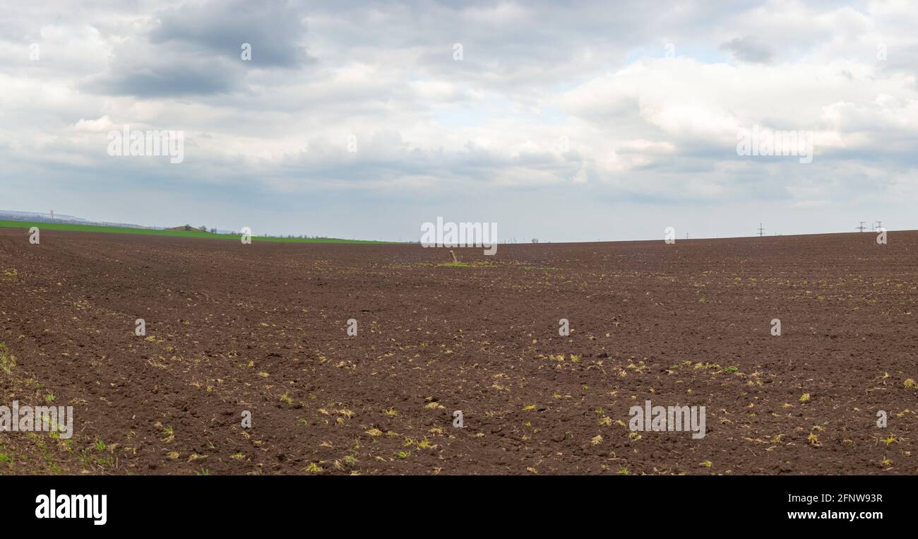 panorama of a landscape photo of the field, after plowing. against a cloudy sky Stock Photo