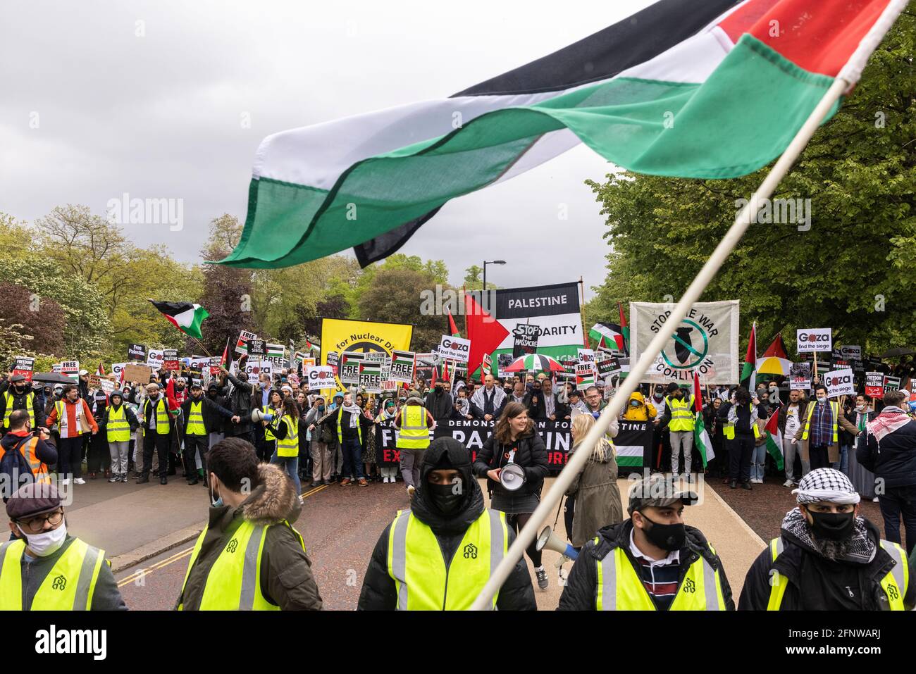 Palestinian flag waved above marching crowd, 'Free Palestine' solidarity protest, London, 15 May 2021 Stock Photo