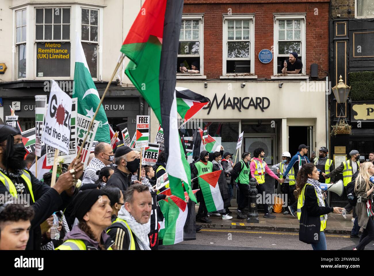 Residents watch marching protesters from window, 'Free Palestine' solidarity protest, London, 15 May 2021 Stock Photo