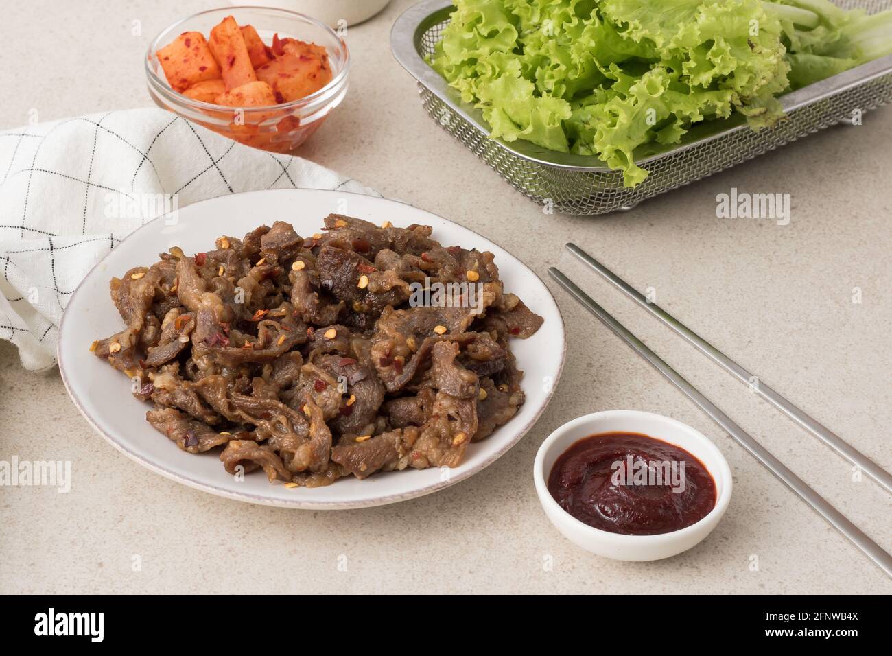 Korean beef bbq samgyeopsal with chili flakes, kimchi radish, lettuce and gochujang dip Stock