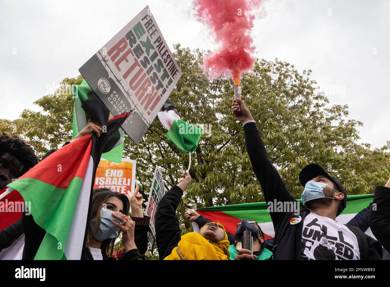 Protesters with flags, placards, and smoke bomb, during 'Free Palestine' solidarity protest, London, 15 May 2021 Stock Photo