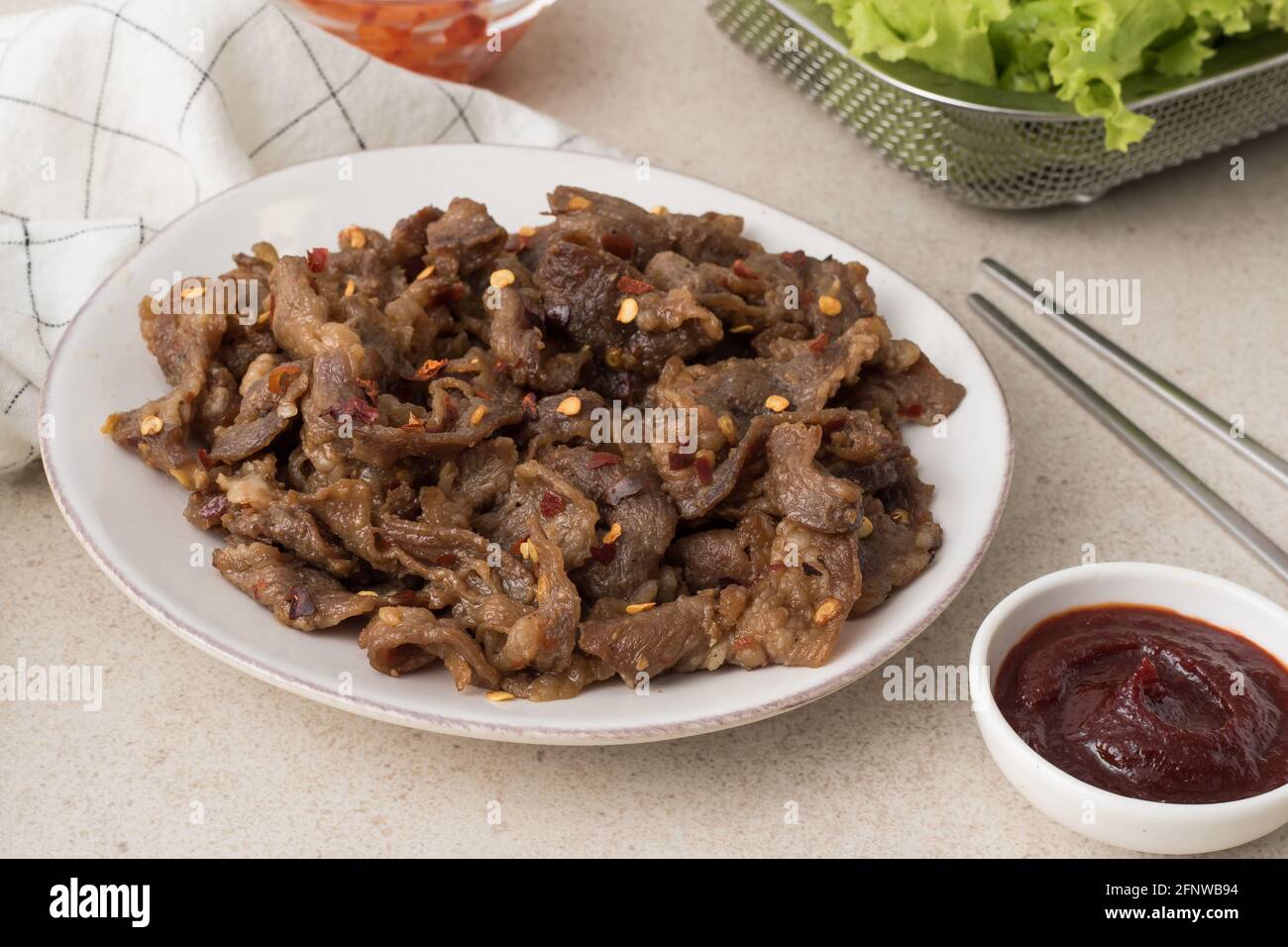 Korean beef bbq samgyeopsal with chili flakes, kimchi radish, lettuce and gochujang dip Stock