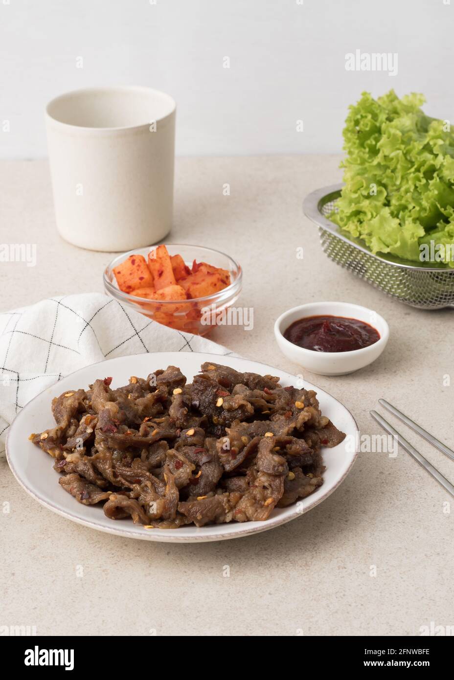 Korean beef bbq samgyeopsal with chili flakes, kimchi radish, lettuce