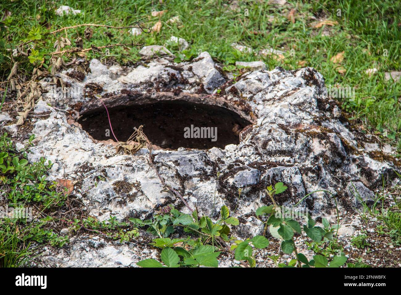 An ancient pit in the southern Caucasus mountains where clay kvevris filled with wine were stored over the winter surrounded by grass and vines - shal Stock Photo