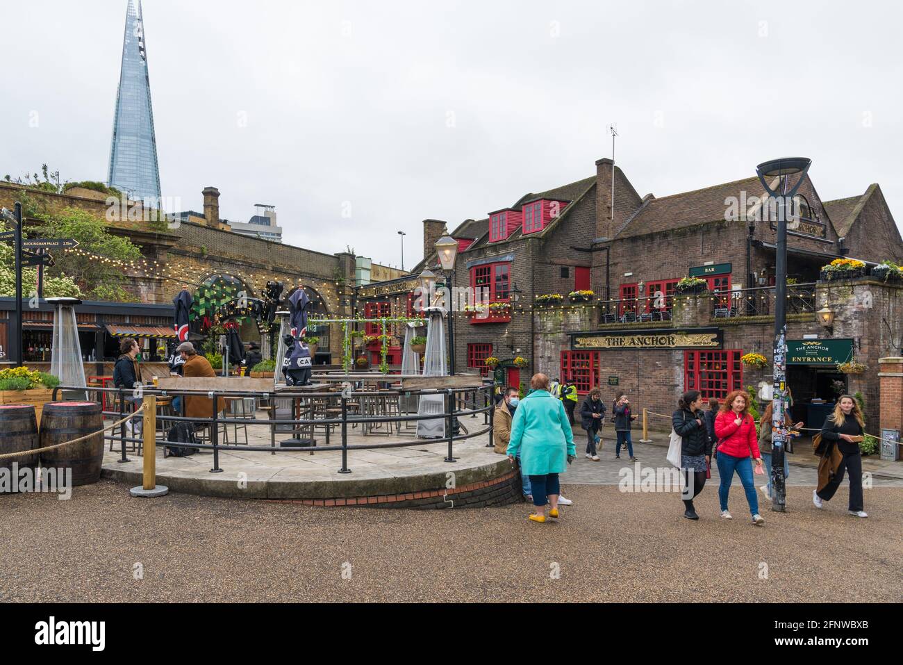 People out and about by The Anchor pub at Bankside in Southwark, London, England, UK. The Shard skyscraper visible in the background. Stock Photo