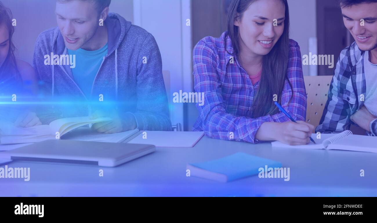 Composition of male and female students studying together with blue glow Stock Photo