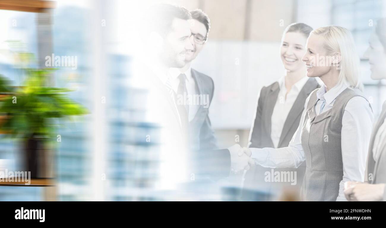 Composition of happy male and female business people shaking hands in ...