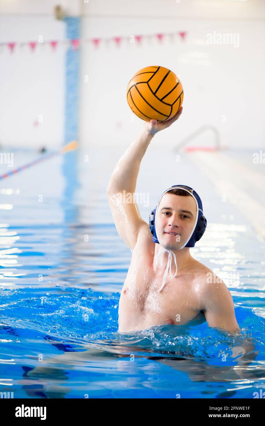 Water polo training. Young sportsman plays water polo in the pool