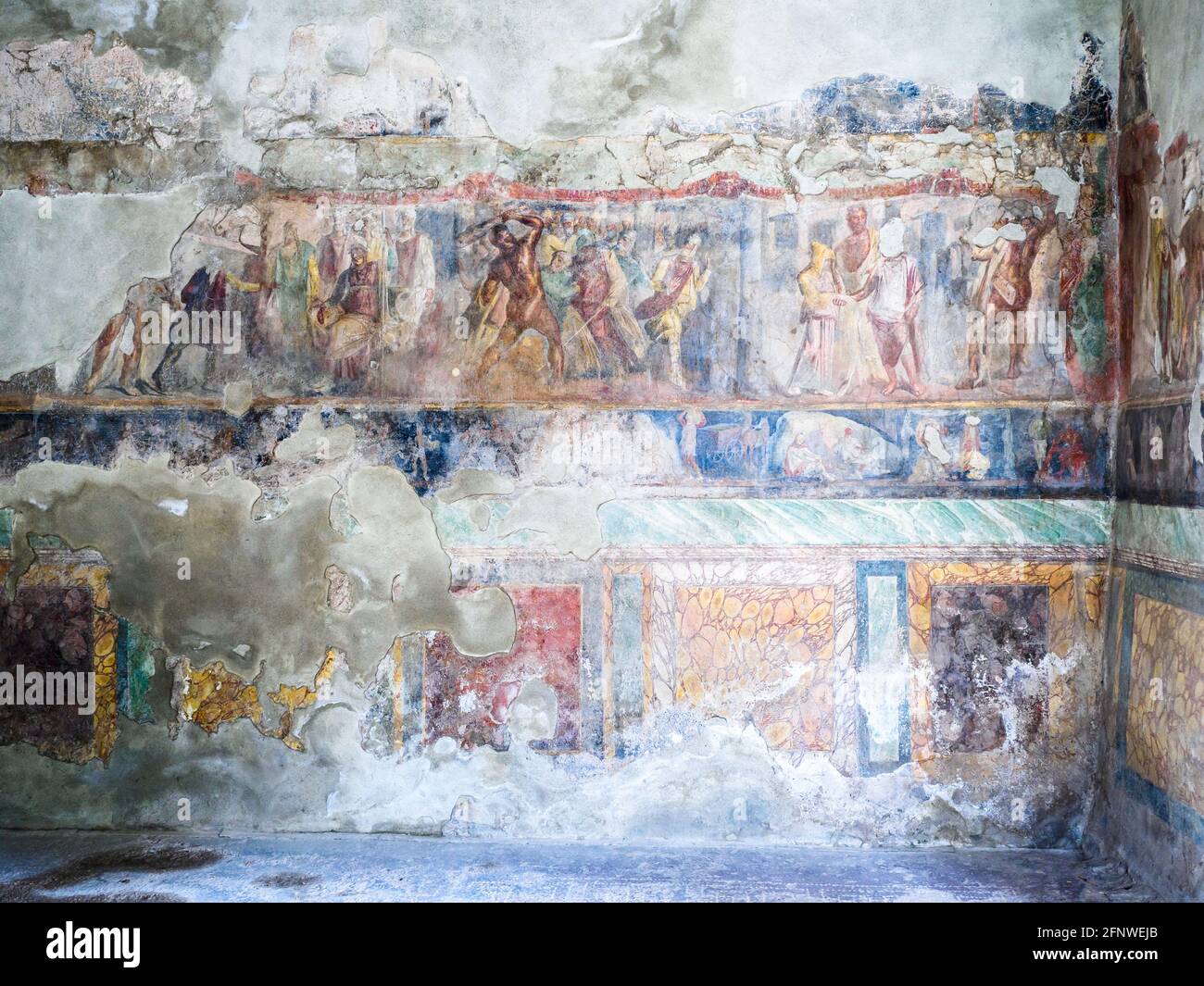 Richly decorated frescoes with scenes from the Illiad above a lower multi-coloured frieze of faux marble. The upper zone contains scenes from the myth of Hercules. Triclinium (dining room) - House of Octavius Quartio - Pompeii archaeological site, Italy Stock Photo