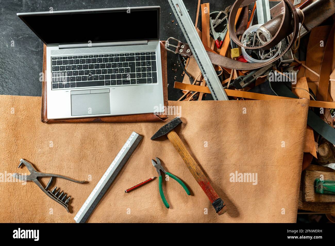 Top view computer laptop hammer and other tools on a desk in a