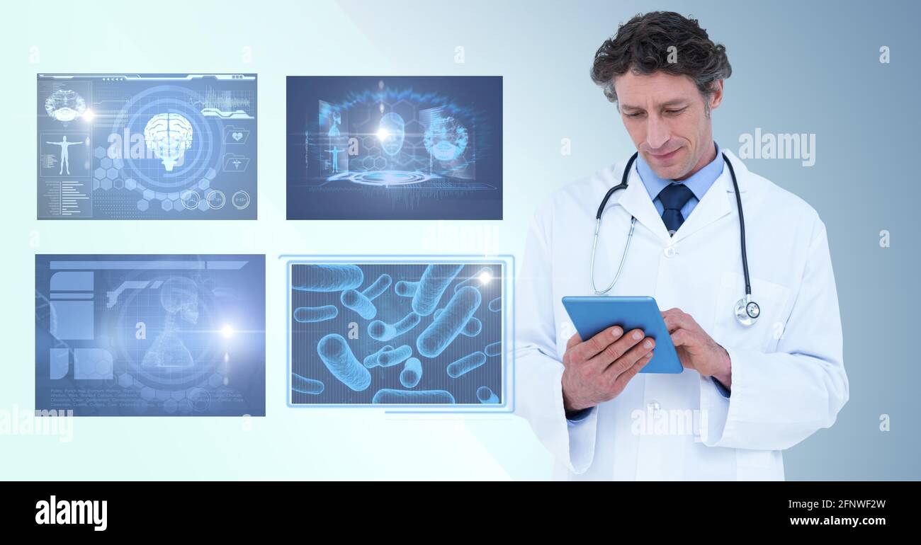 Composition of male doctor using tablet and screens with medical data processing Stock Photo