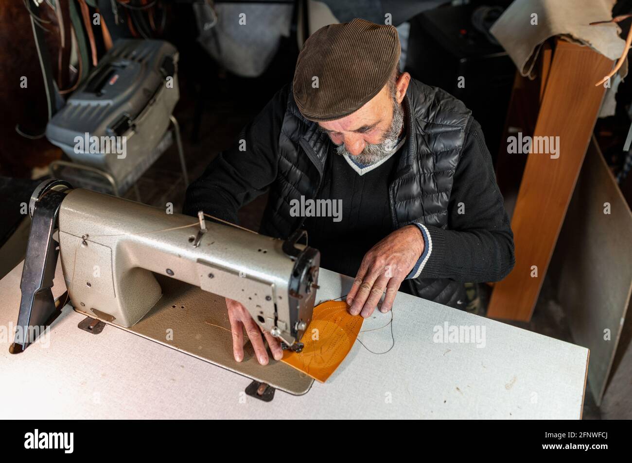 Top view old man in making leather goods working with sewing