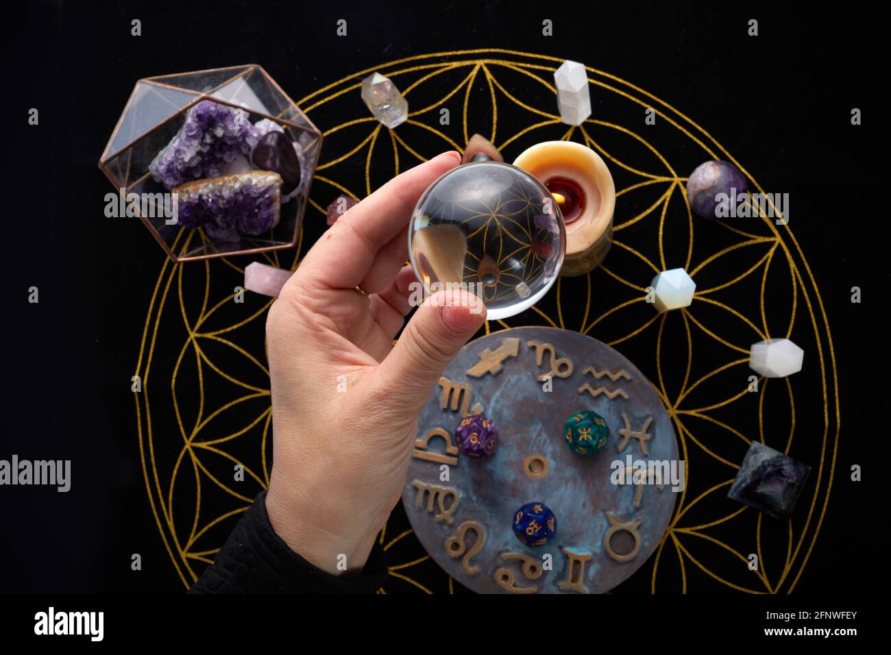 Fortune Telling Table with esoteric objects and hand holding crystal