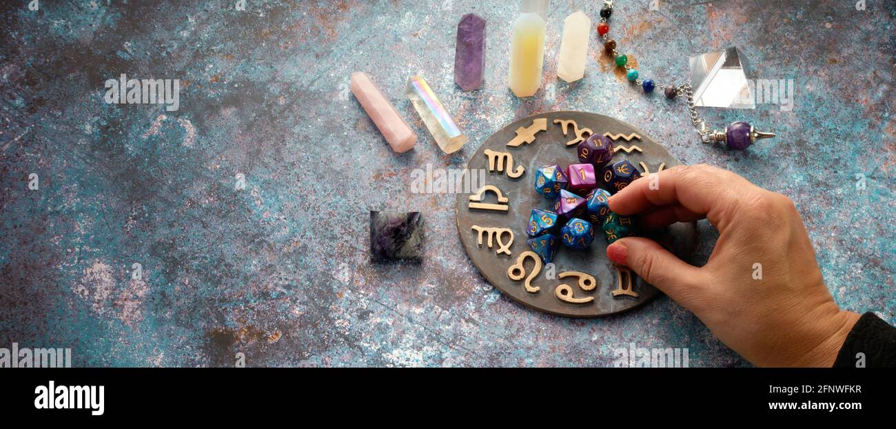 zodiac horoscope symbol with hands and healing crystals on rustic background