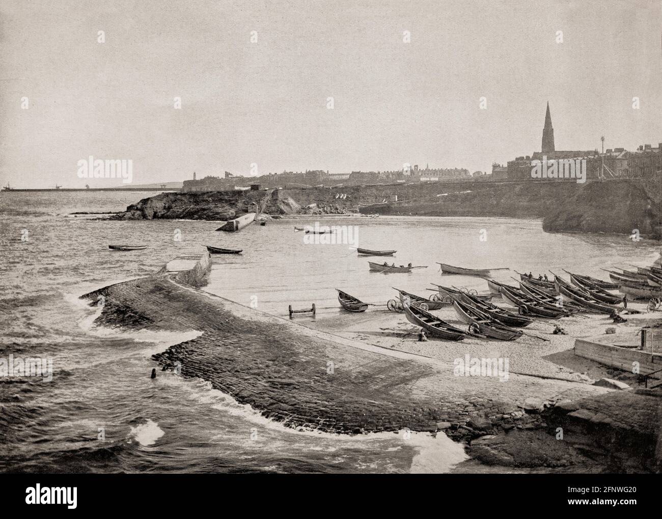 A late 19th Century view of fishing boats aka or cobles drawn up on the beach at Cullercoats, between Tynemouth and Whitley Bay,  Northumberland, England. The harbour is the home of the Dove Marine Laboratory of 1897, a research and teaching laboratory which forms part of the School of Marine Science and Technology within Newcastle University. Stock Photo