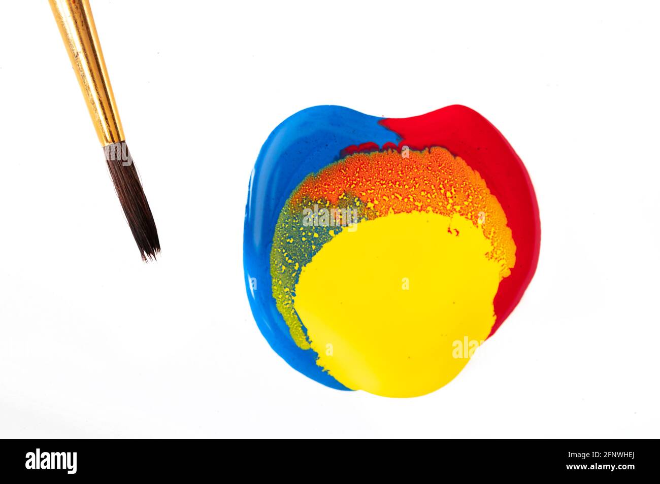 Red, yellow, and blue paint with clean paintbrush on the side Stock Photo