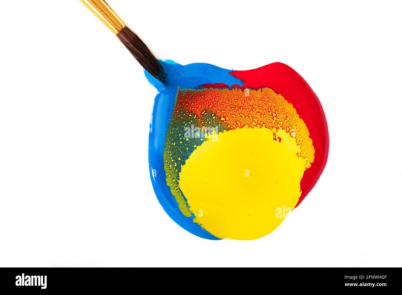 Red, yellow, and blue paint with paintbrush dipped in Stock Photo