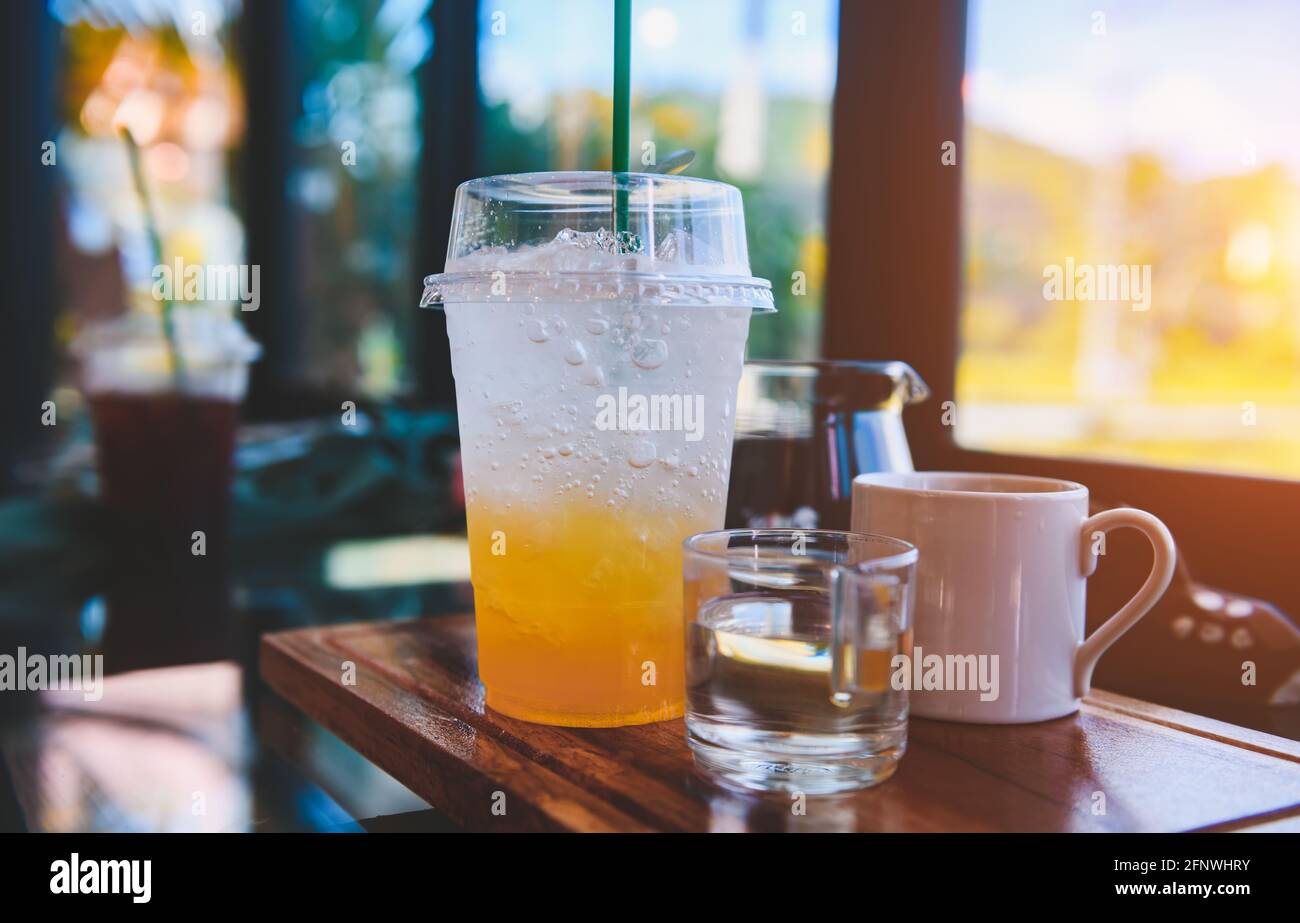 Orange lemon juice with soda ice and cold drink in coffee shop with indoor low lighting. Stock Photo