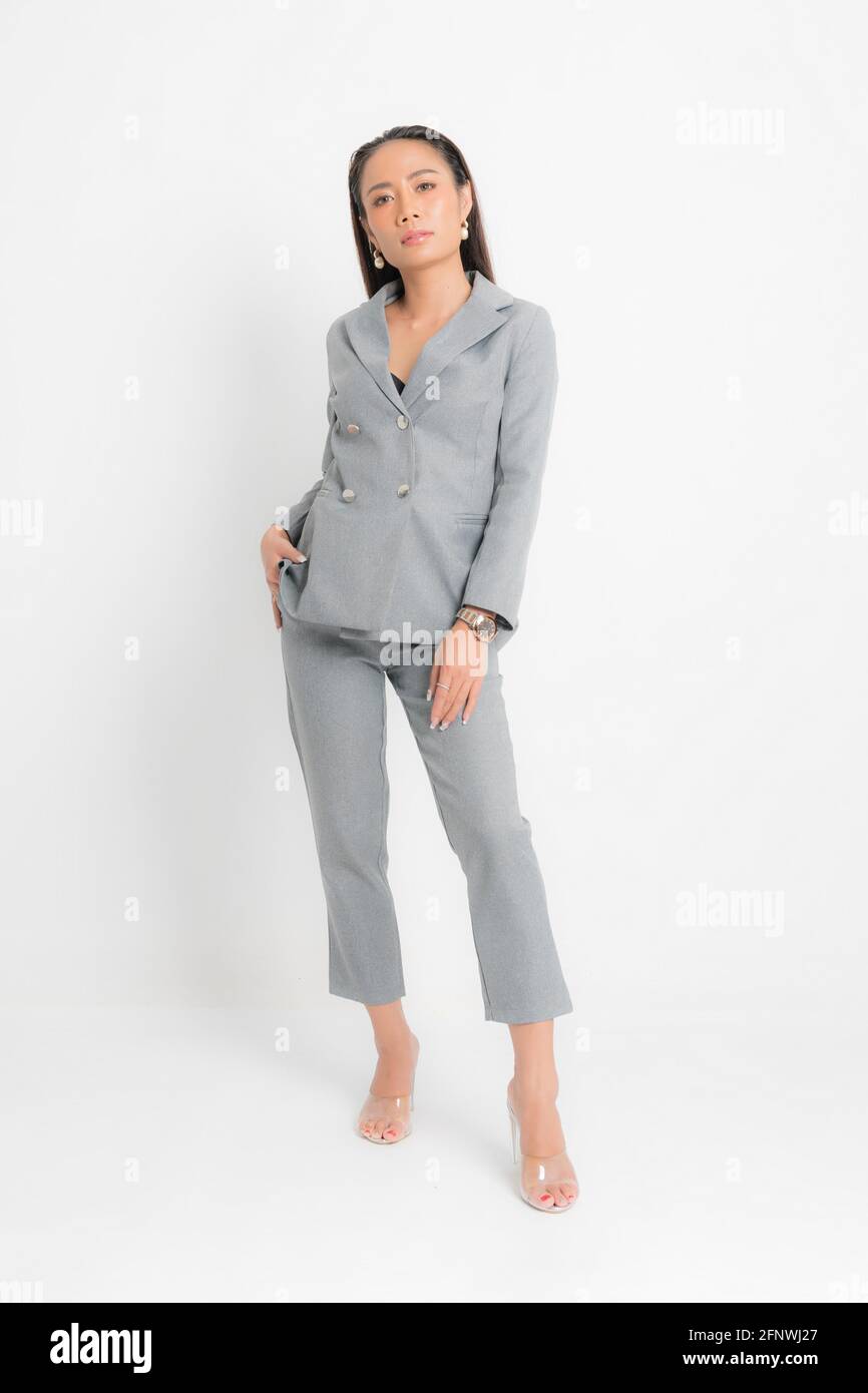 Fashion style catalog clothing for business woman black long hair natural make up wear gray suit costume perfect body shape suit at studio shoot on wh Stock Photo
