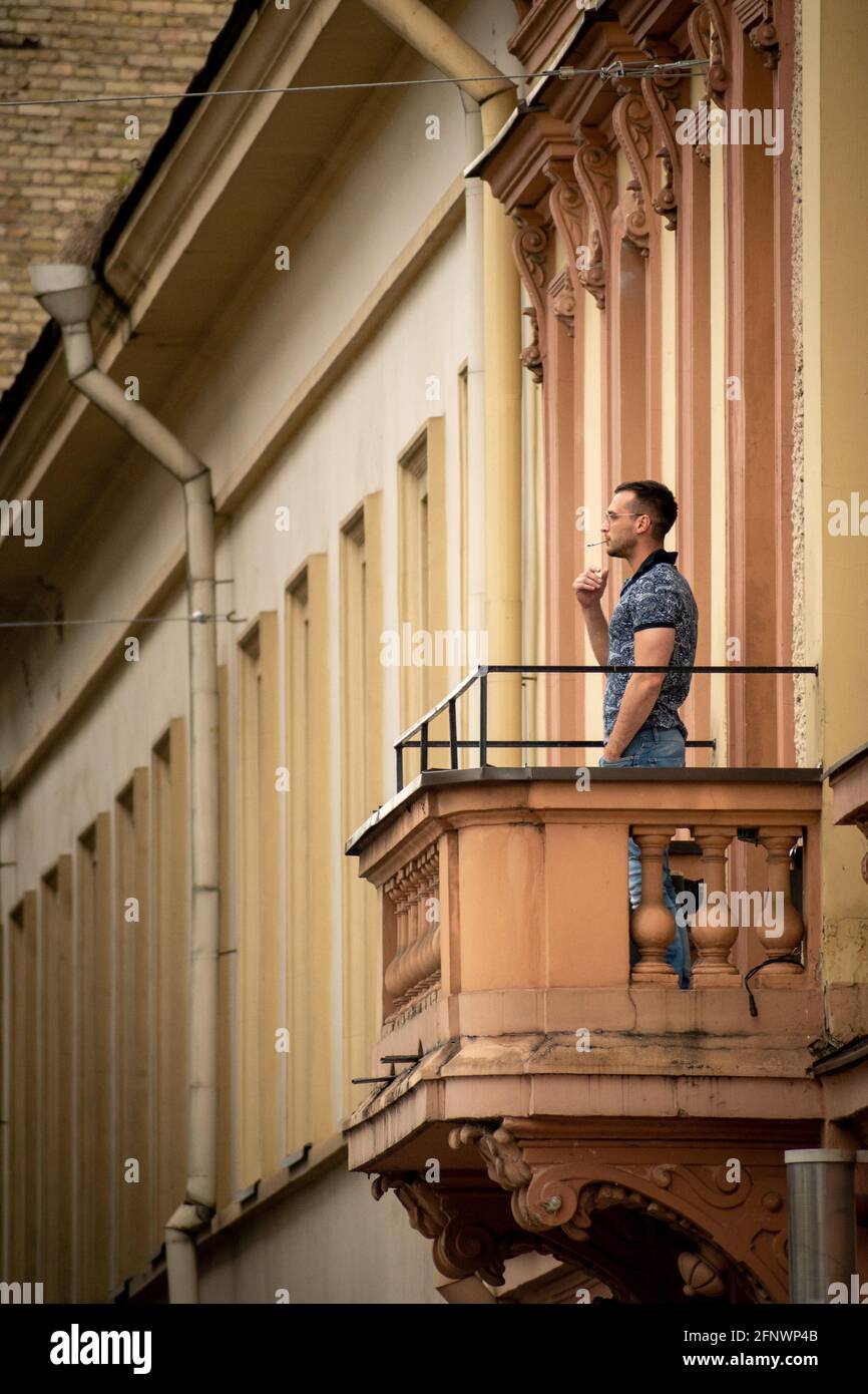 Man or boy smoking cigarette outside on the balcony, vertical Stock