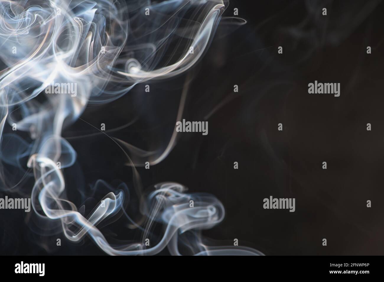 blurry smoke of an incense stick as background photo with copy space Stock Photo