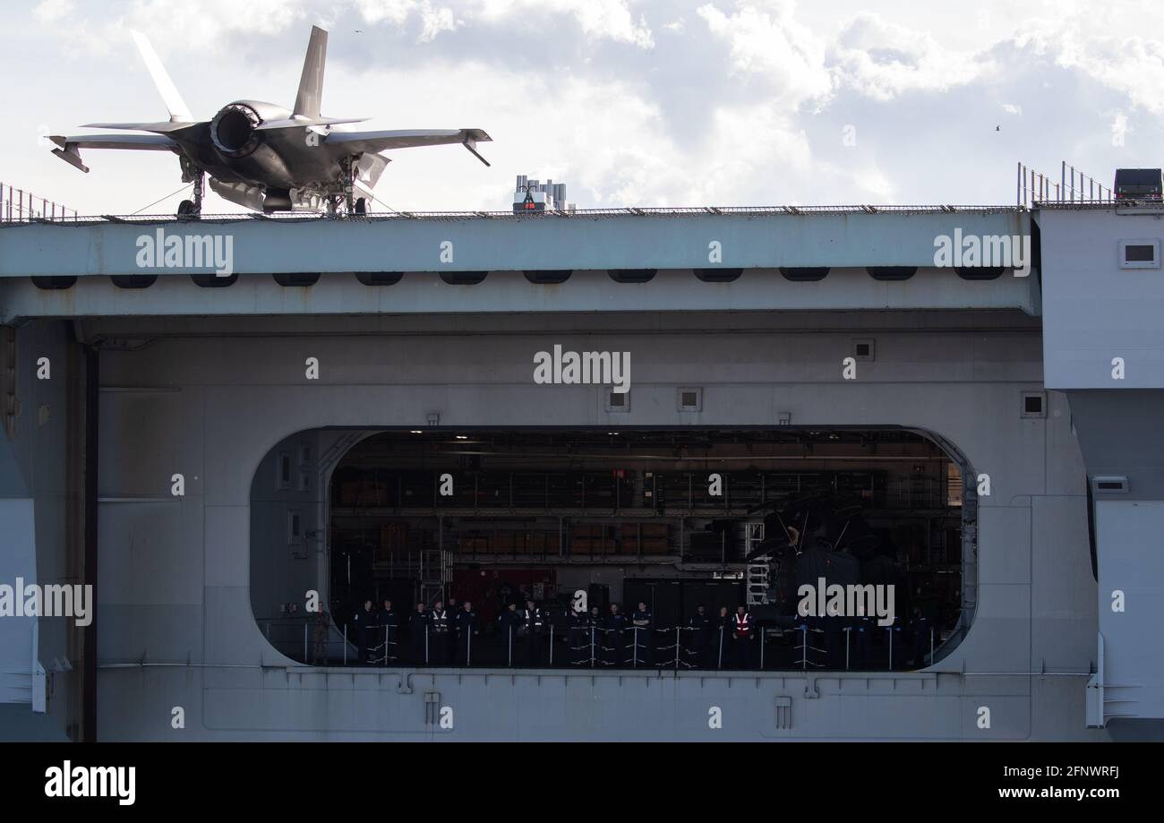 Ship's company look out from the hanger as the Royal Navy aircraft ...