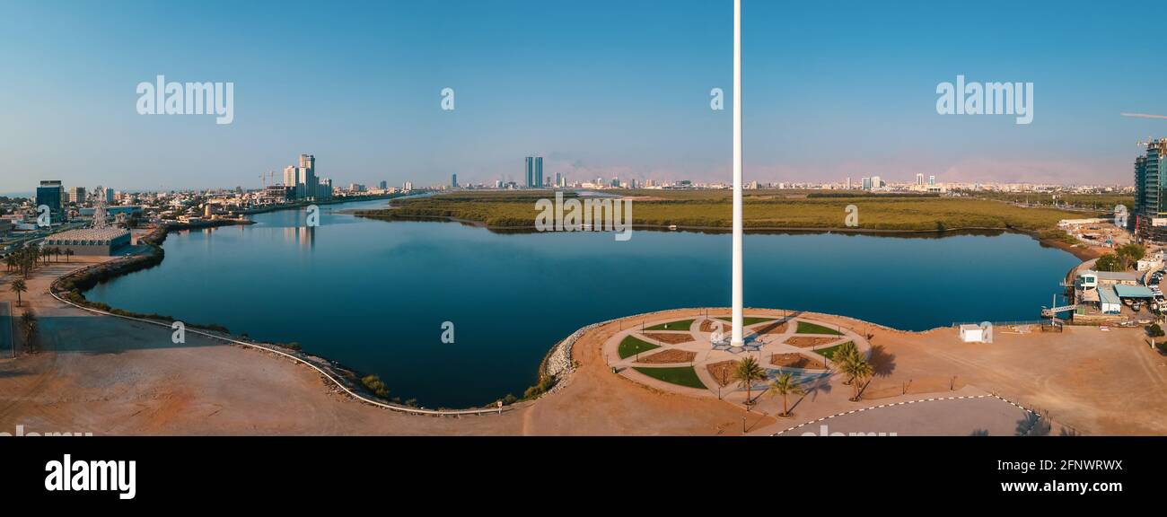 UAE national flag pole and Ras al Khaimah emirate in the northern United Arab Emirates aerial skyline landmark and skyline view above the mangroves an Stock Photo