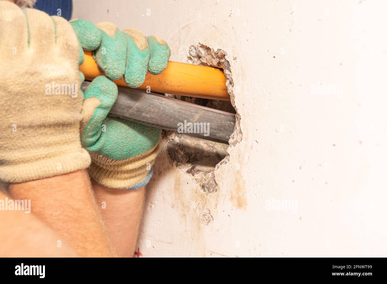 Close up of a wall breakthrough through a core hole by professionals for the installation of a gas connection and for a fibre optic cable Stock Photo