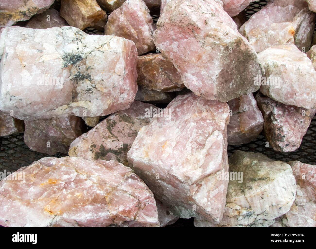 A macro photograph of rose quartz stones piled up together with a slight bokeh effect. Stock Photo