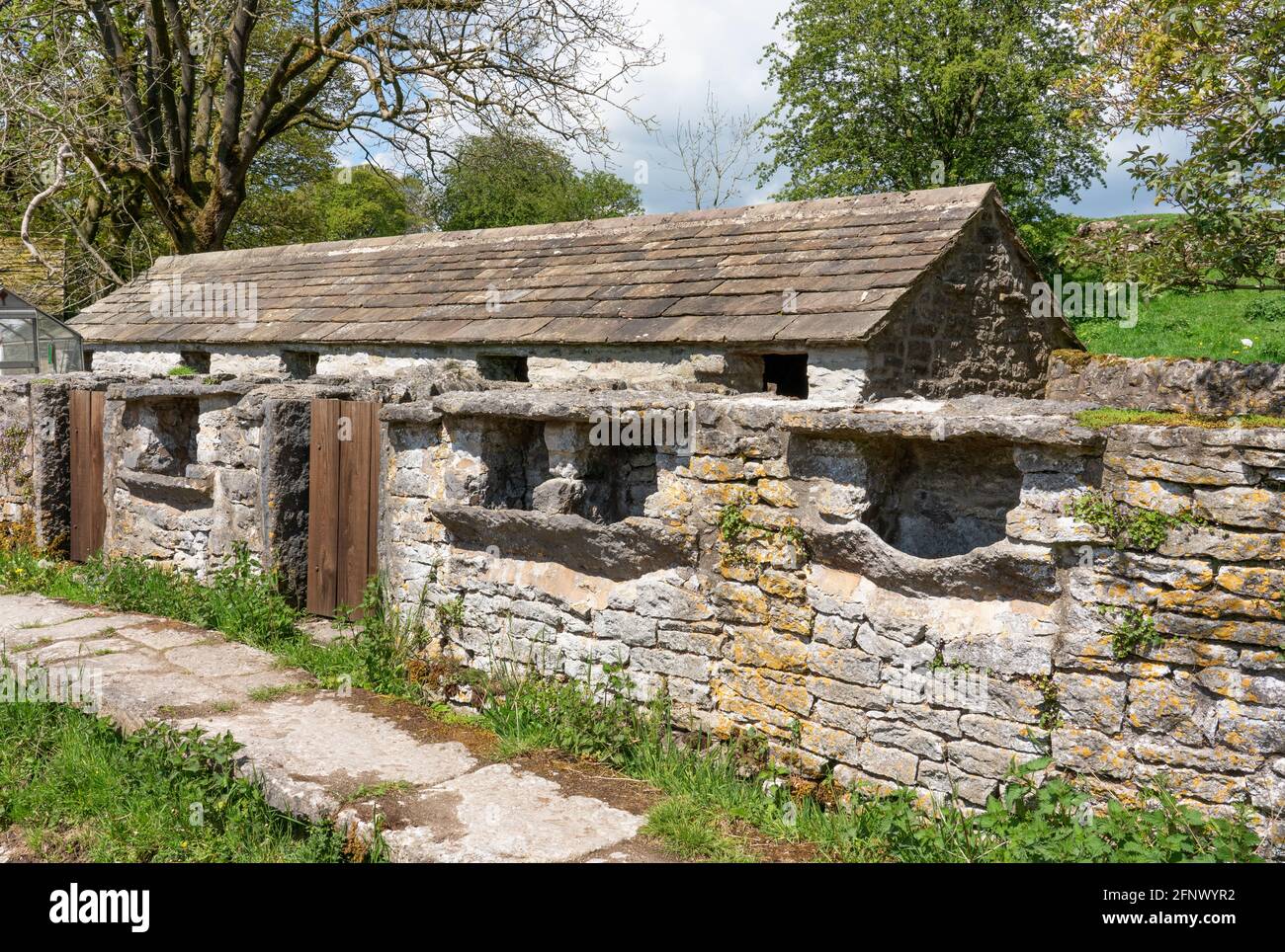 Row of Grade II listed pigsties with feeding hoppers at One Ash Grange farm above Lathkill Dale in the Derbyshire Peak District UK Stock Photo