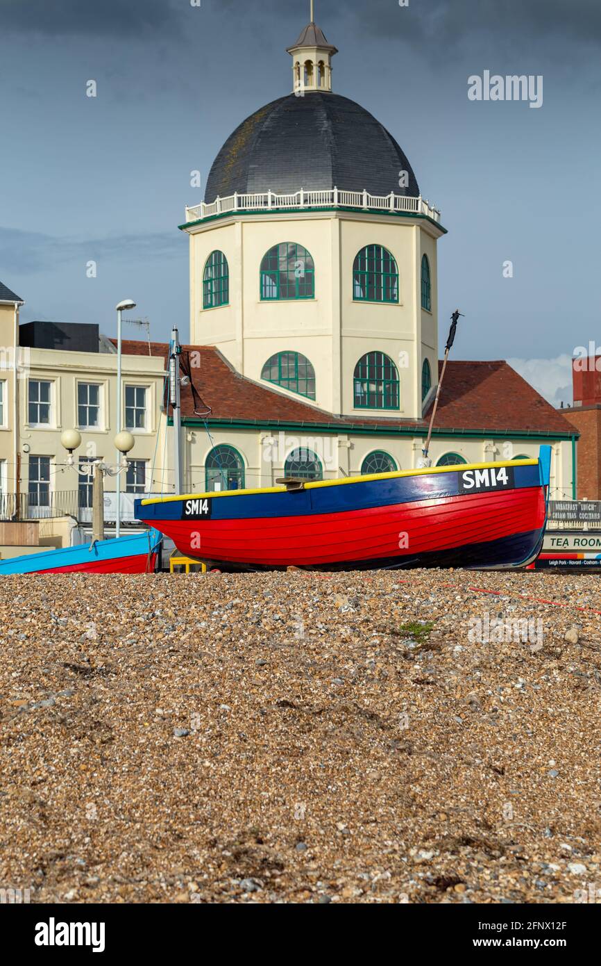 Fishing boats sit on the beach in front of the Grade II listed Dome Cinema building, originally opened in 1911, one of oldest working cinemas in UK. Stock Photo