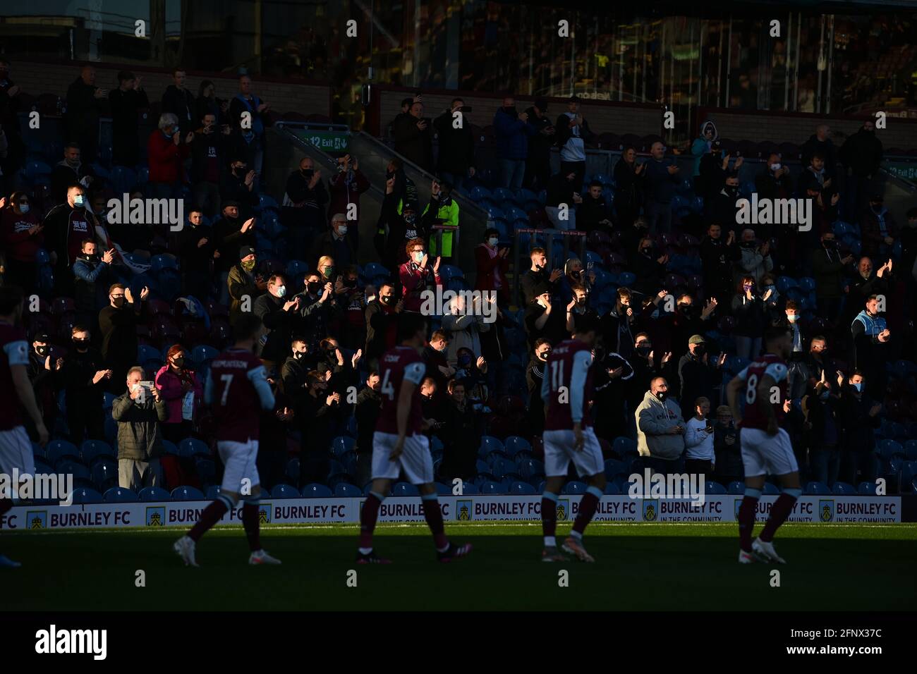 Burnley fans applaud their side during the Premier League match at Turf Moor, Burnley. Picture date: Wednesday May 19, 2021. Stock Photo